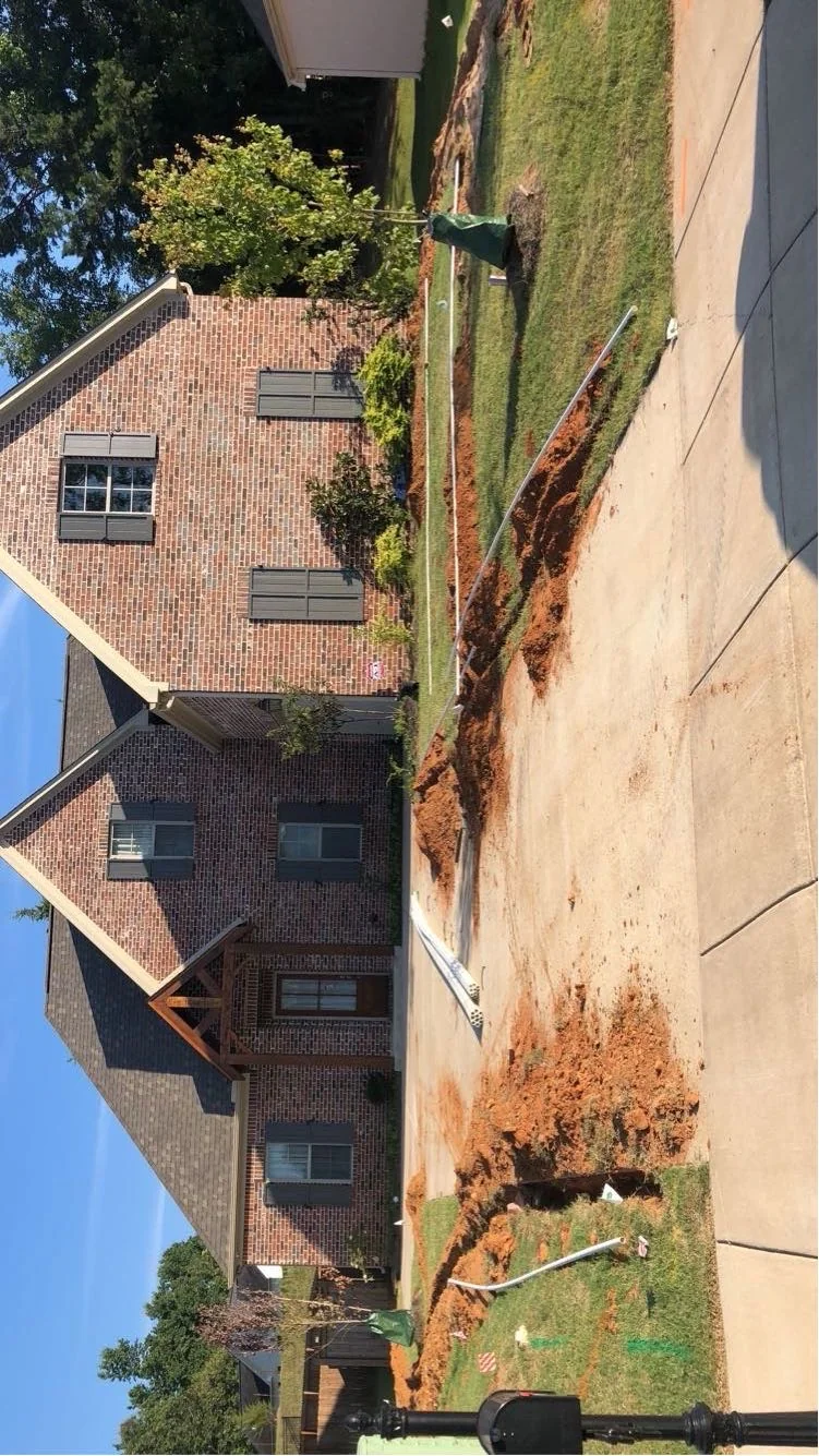Irrigation system installation in progress at a new-build home in Oxford MS — trench cut along the driveway by Oxford Lawn Pro